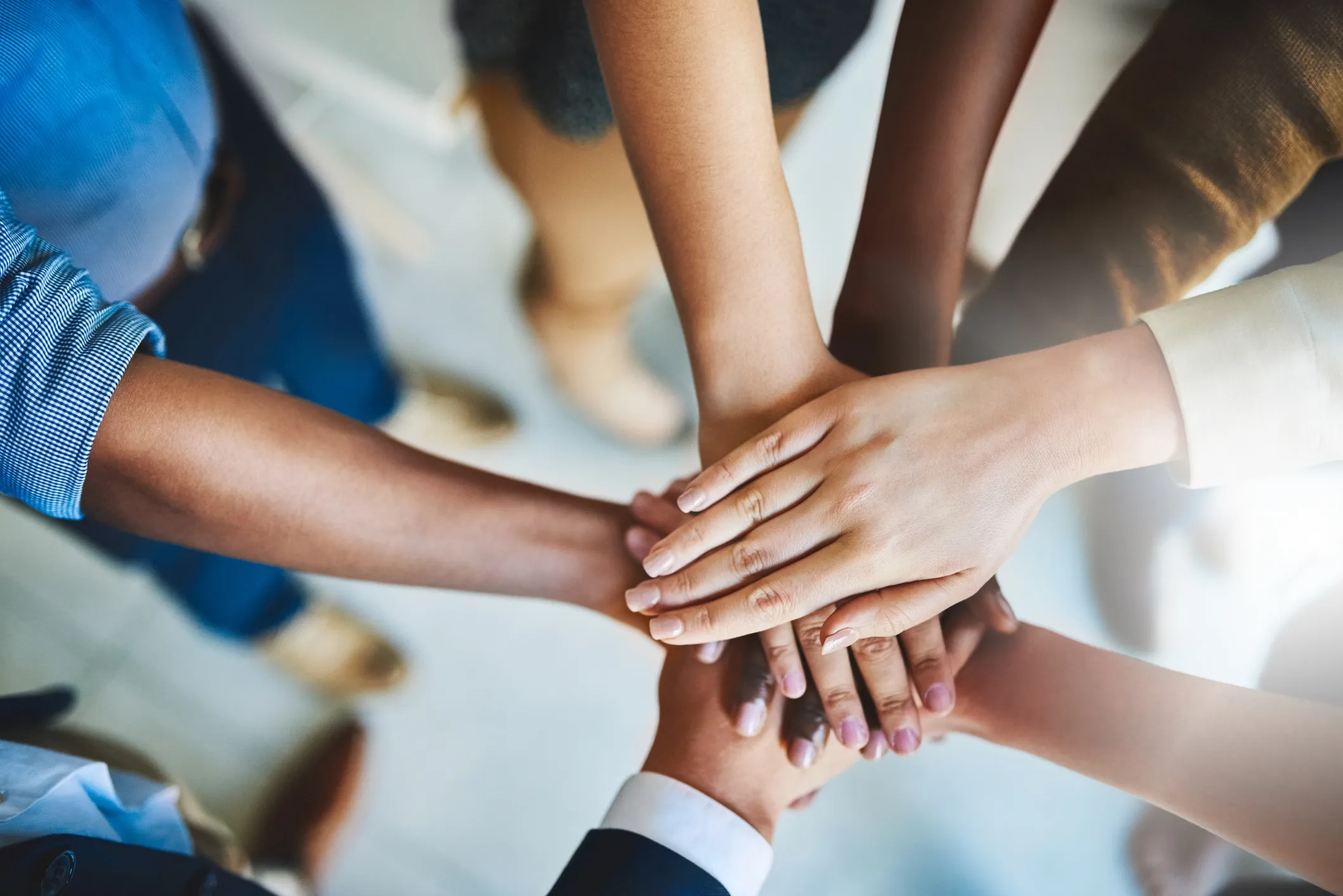 Hands stacked together in a gesture of teamwork