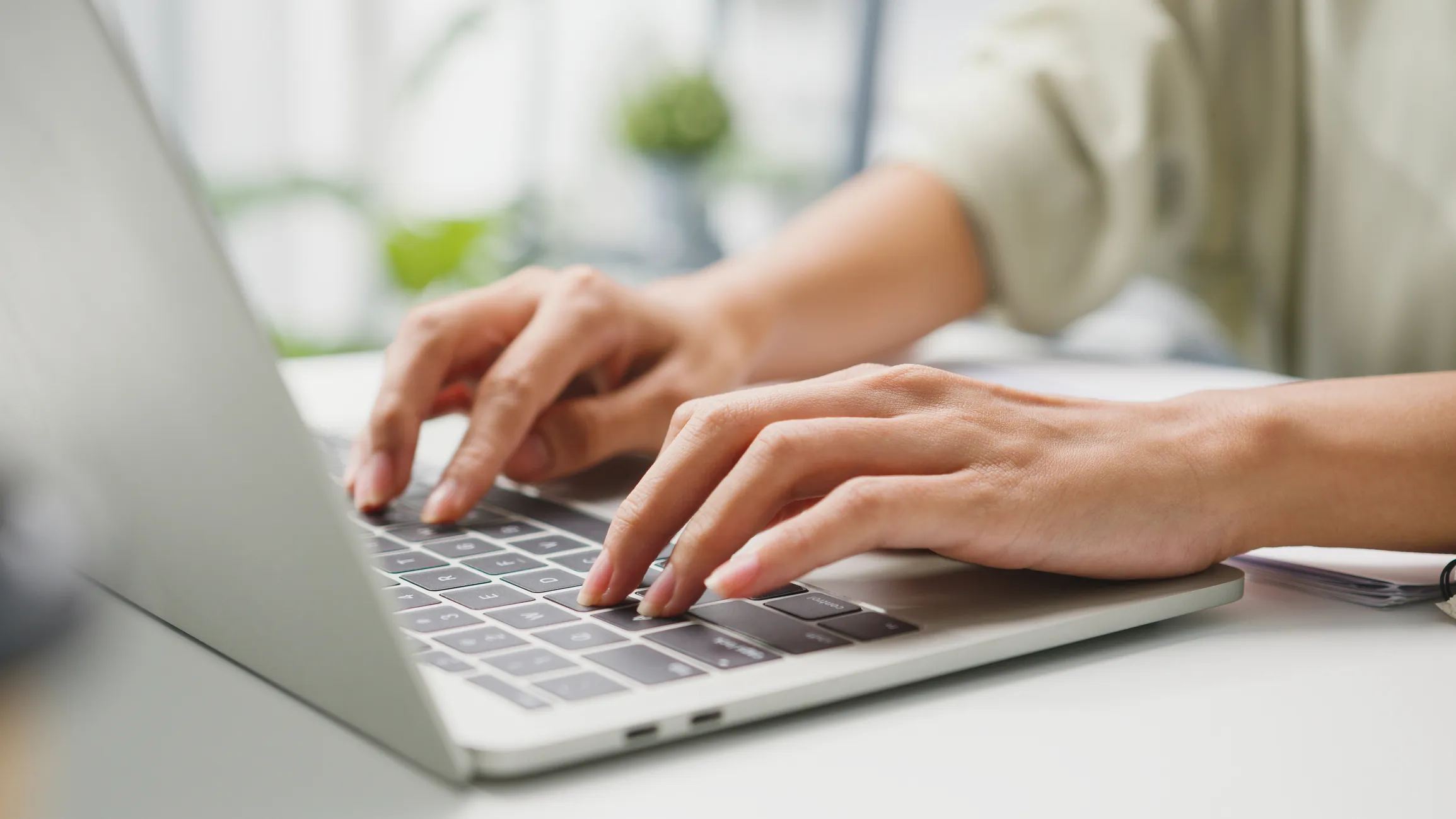 Hands typing on a laptop keyboard