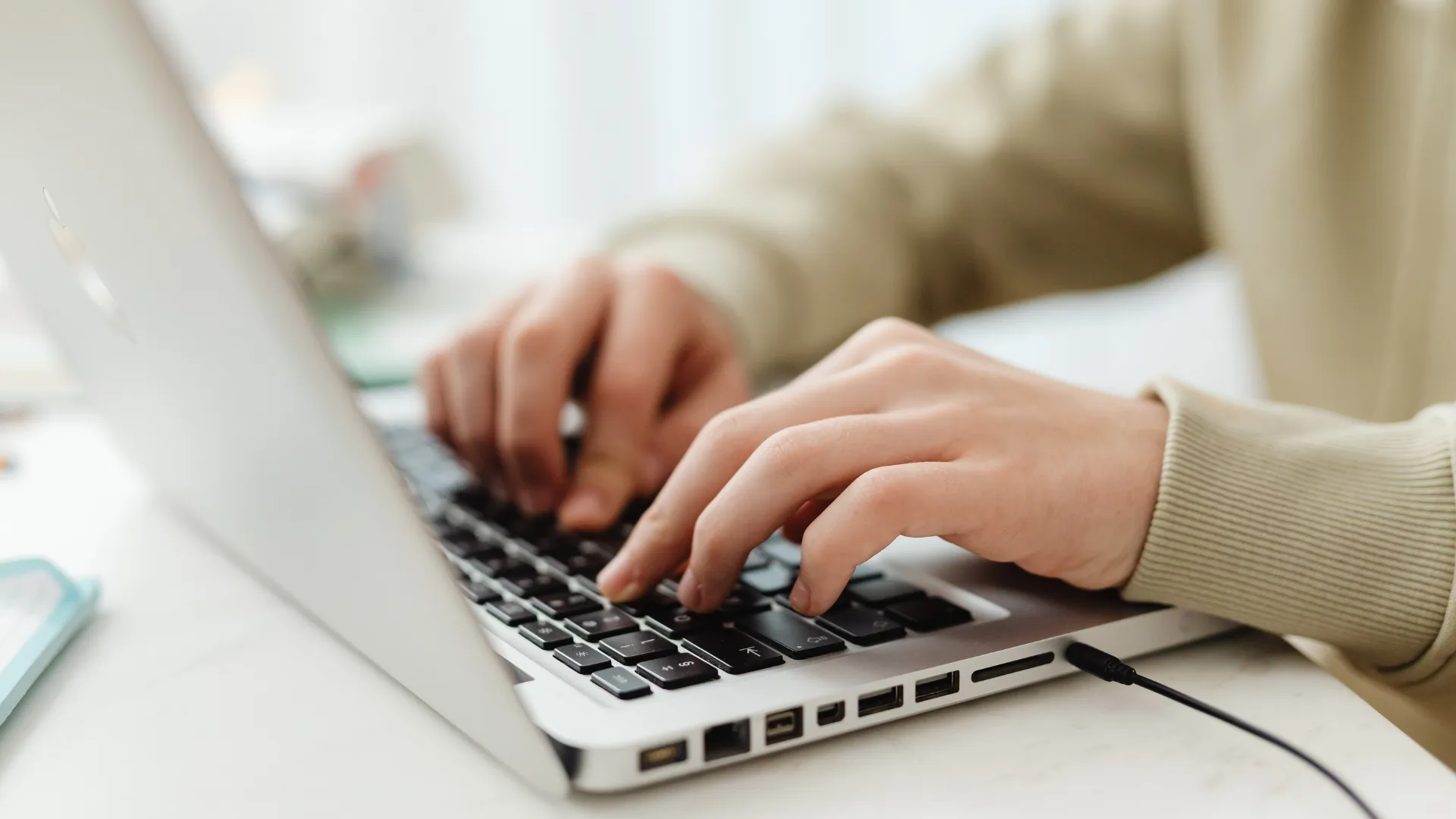 Hands typing on a laptop keyboard