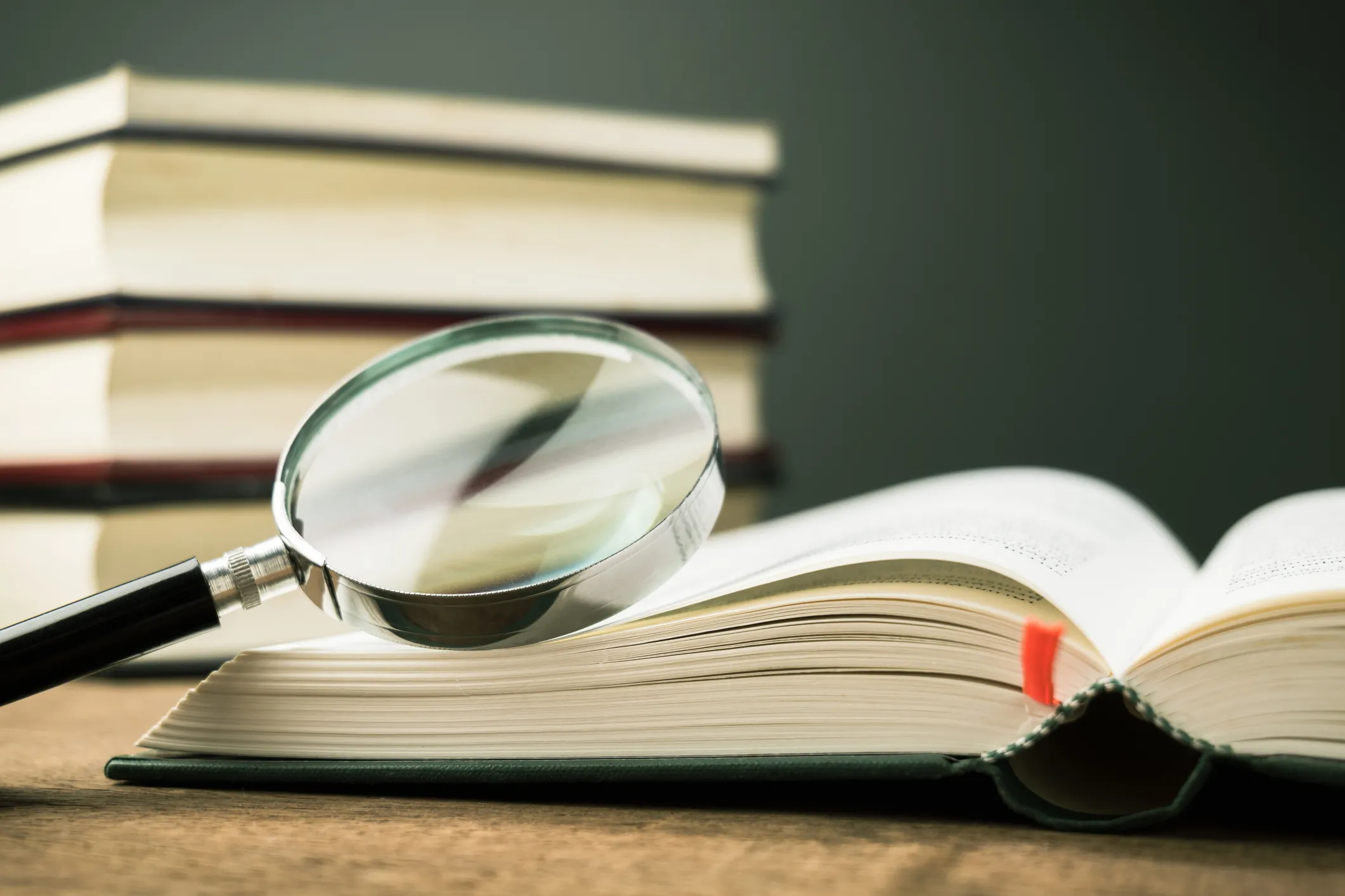 A magnifying glass resting on the open pages of a book