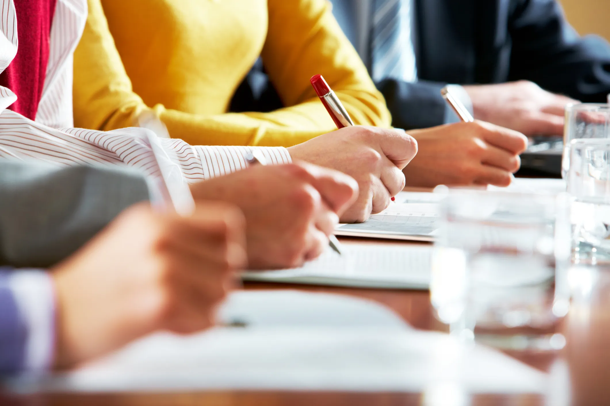 Close-up of people writing notes during a meeting
