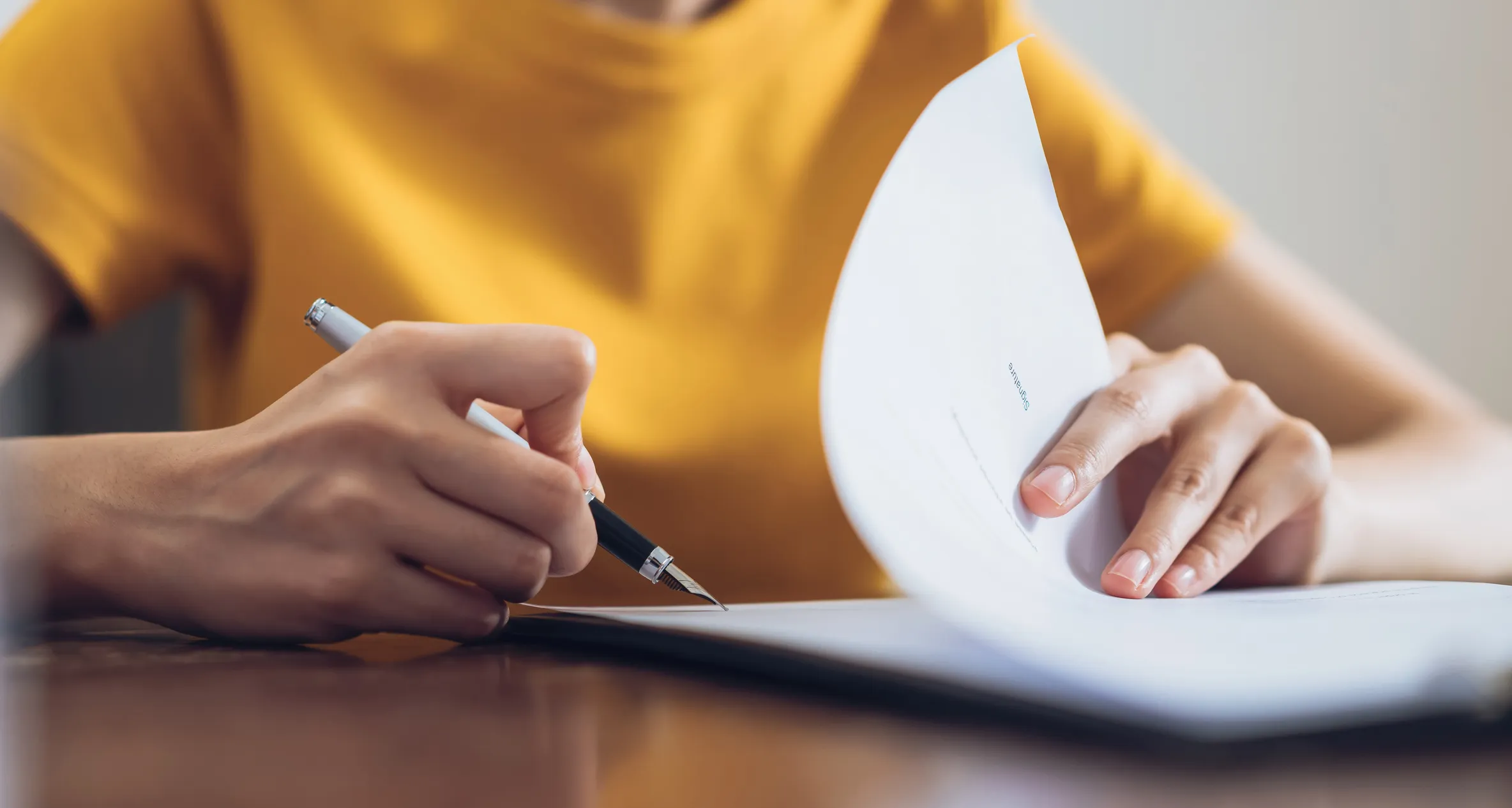 Person writing and flipping through a document